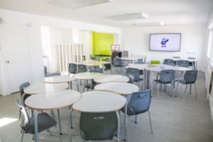 A bright, modern junior classroom with whiteboard desks.